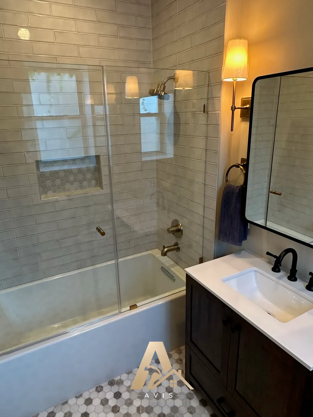 Glass panel on the tub and shower beside the new vanity