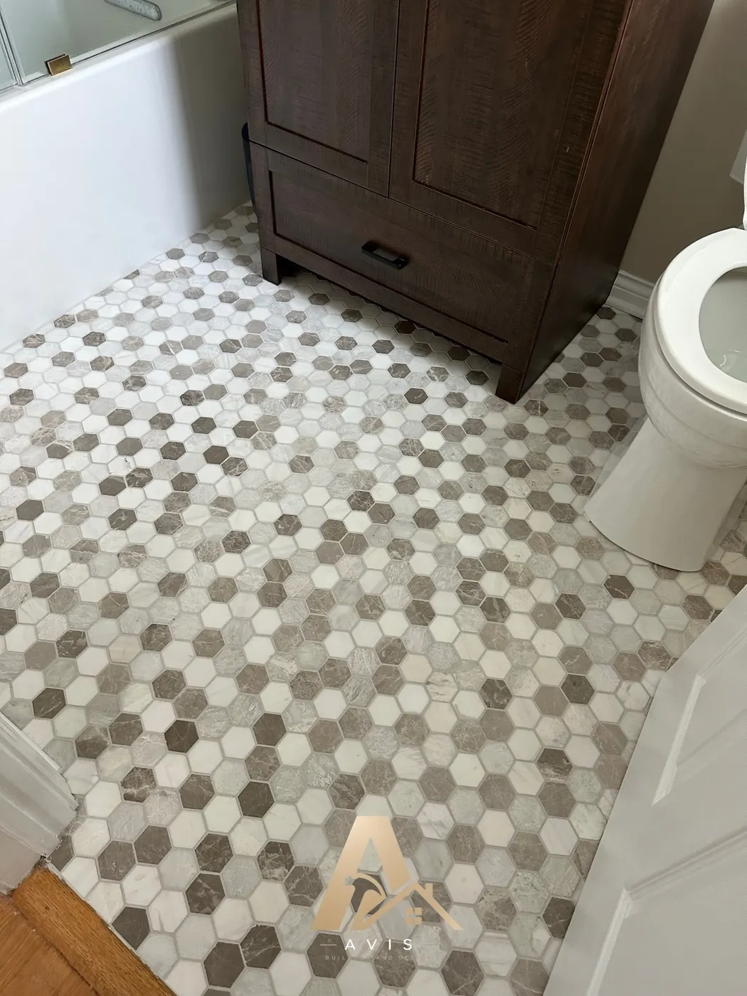 Mosaic floor tile across the bathroom floor