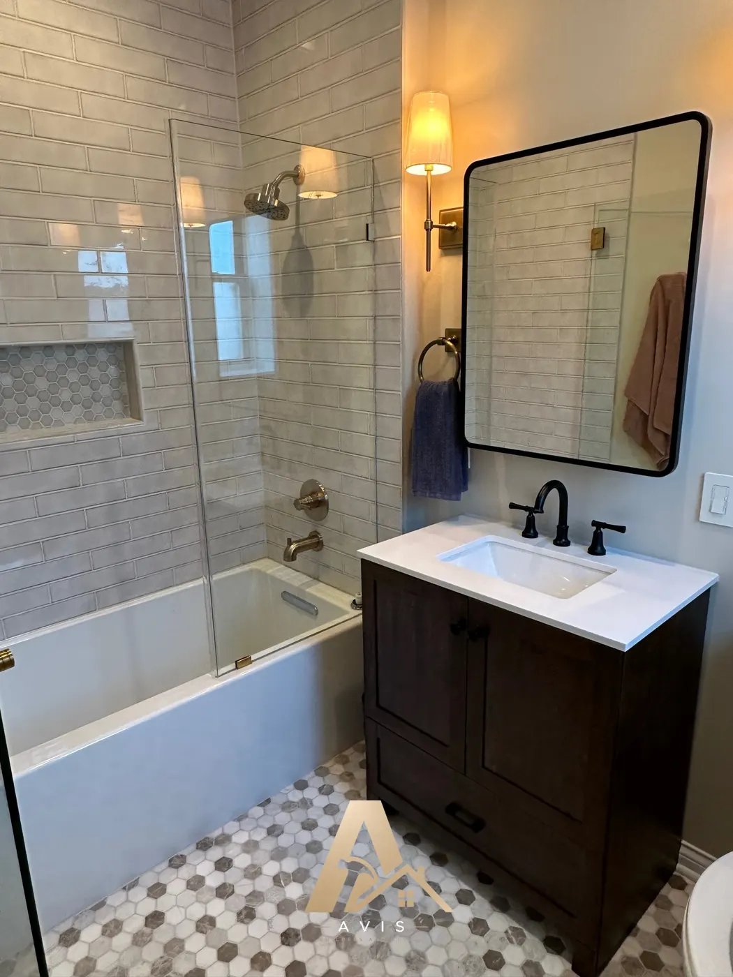 Brown vanity beside a tub and shower with glossy subway tile in a San Mateo bathroom