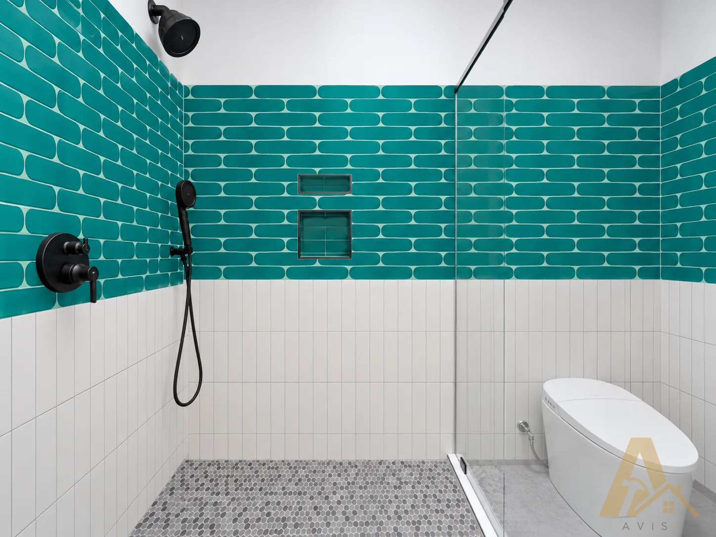 Walk-in shower with teal picket tile above white tile, black fixtures and a pebble floor