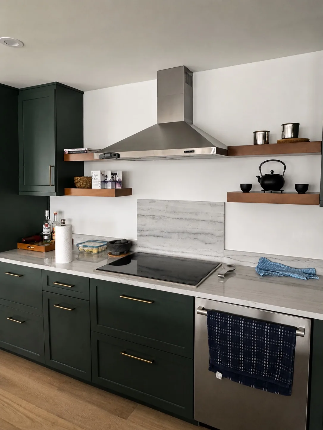 Dark green kitchen run with a flat glass cooktop, stainless hood and marble backsplash