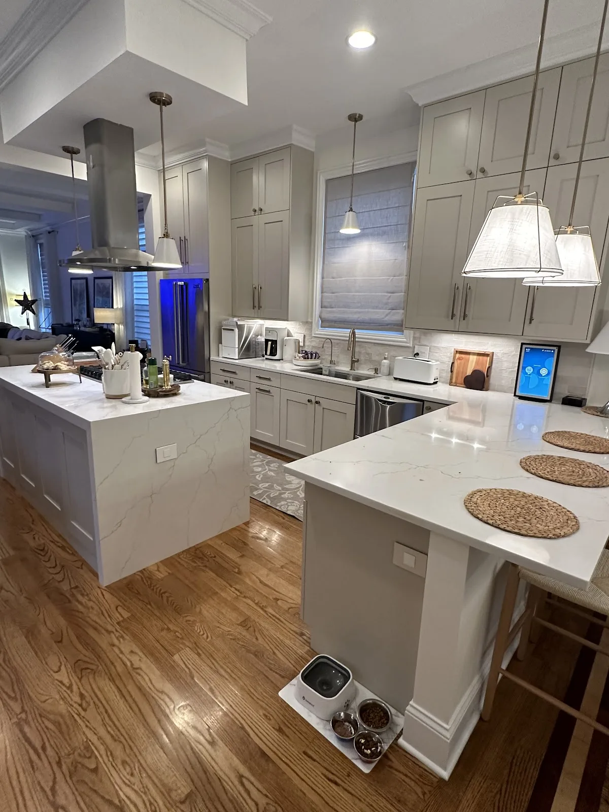 Greige shaker kitchen with a quartz waterfall island and hardwood floor