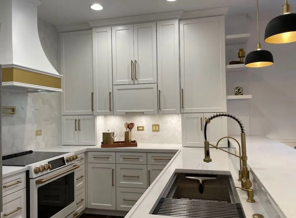 White kitchen with a brass tap, undermount sink and black dome pendants